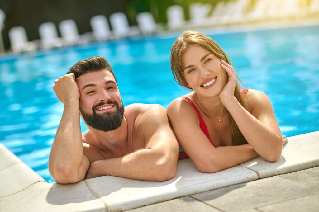 mann und frau lächelnd im swimmingpool